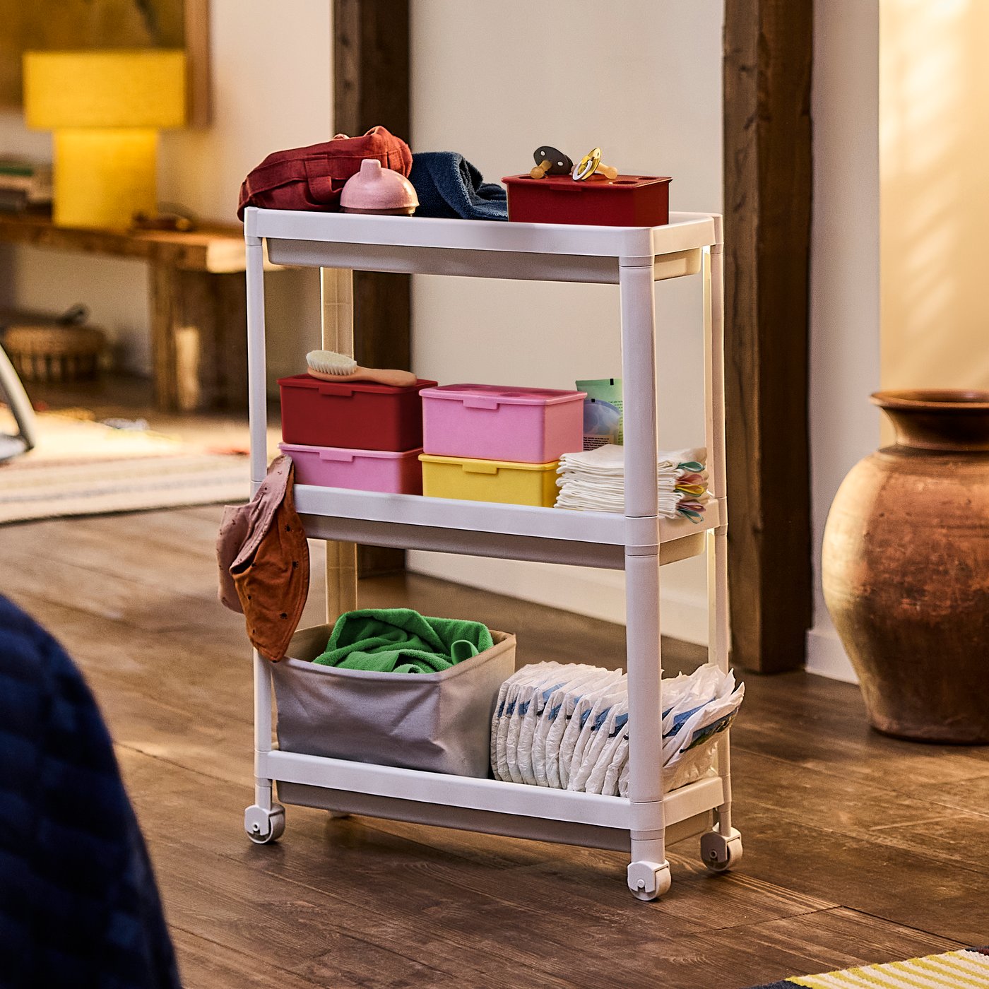 A white VESKEN trolley with wheels stores and organises nappies, flannels and other baby items to make nap time easier.