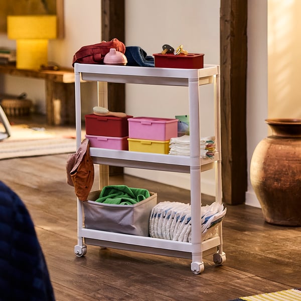 A white VESKEN trolley with wheels stores and organises diapers, washcloths, and other baby items to make nap time easier.