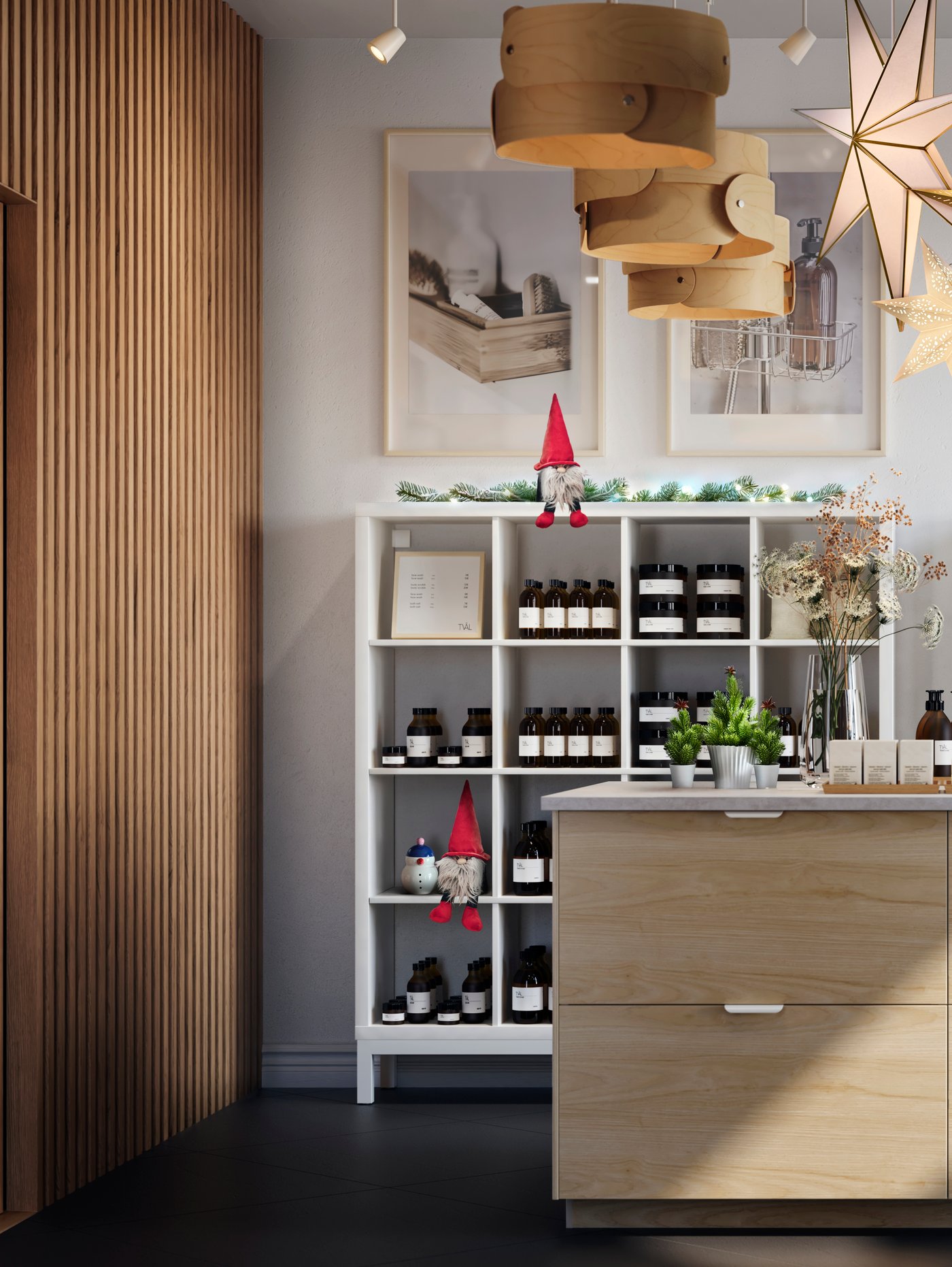 Interno di un negozio luminoso e spazioso il cui punto focale è una grande isola cucina con frontali per cassetti ASKERSUND effetto frassino chiaro. Decorato con luci a LED STRÅLA e decorazioni VINTERFINT.