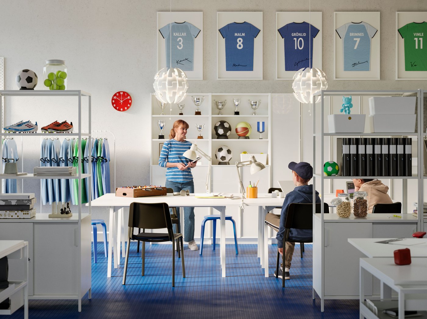 An open meeting area with white TROTTEN tables, black chairs and BILLY bookcase in an office with blue floor and white walls.