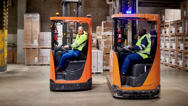 Deux collaborateurs dans des fenouics dans un entrepôt