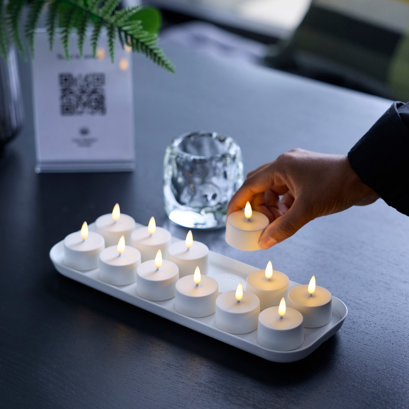 SKATGÅS 12-pack LED tealights on a table.
