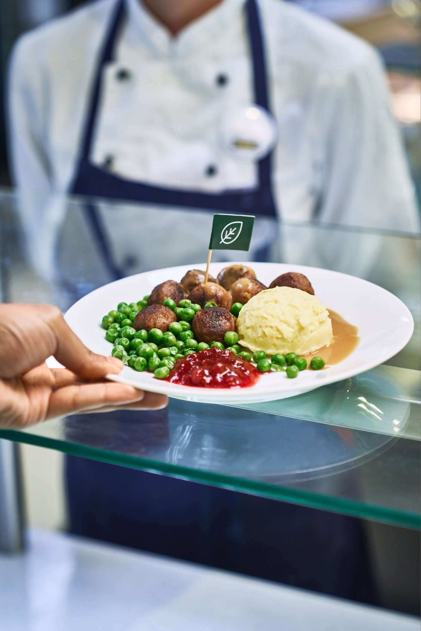 Henkilö nostaa pyörykkäannosta IKEA-ravintolan tiskiltä.