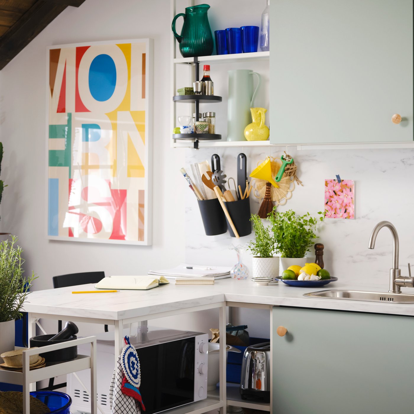 Eine Küche mit ENHET Fronten in blassem Graugrün, einem ENHET Regalrahmen in Weiß und einem ENHET Drehregal.