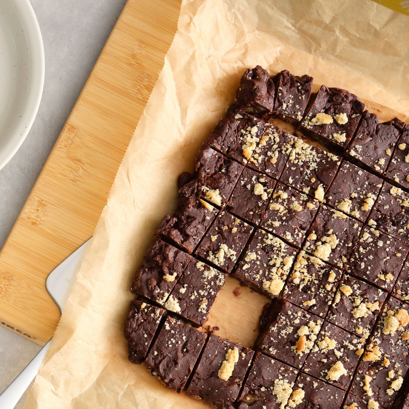 A close up of a batch of chocolate fudge made with brown BJÄLLRA oat biscuits neatly arranged on a wooden counter.