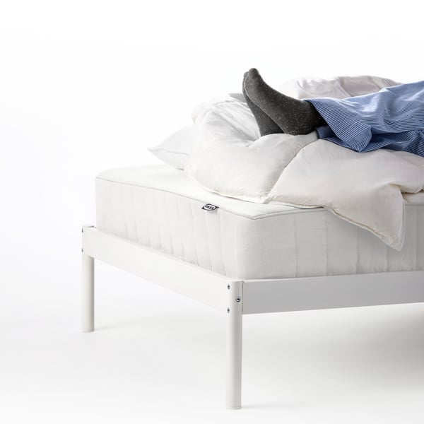 A person resting on a bed, with just the feet showing in frame.