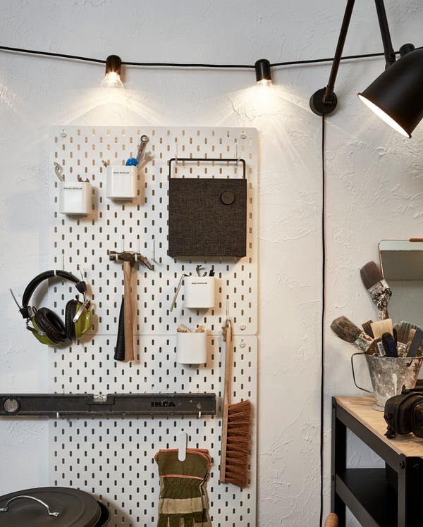 Eine Wand mit Lochplatte, an der u. a. Werkzeug und der ENEBY Bluetooth-Lautsprecher zu sehen sind.