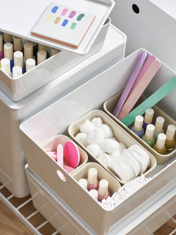 White KUGGIS boxes in different sizes with nail polish and colourful manicure supplies neatly kept in NOJIG organisers.