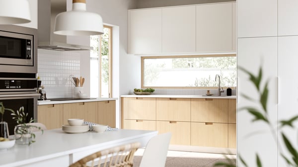 A sun-drenched kitchen in modern style. The bottom cabinets have FRÖJERED fronts and the top cabinets have VEDDINGE fronts.