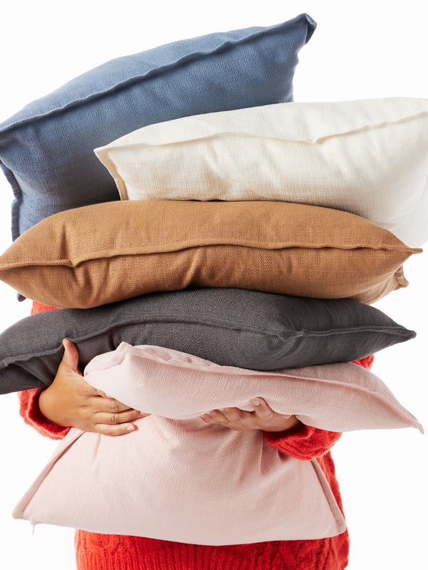 A light pink LAGERPOPPEL cushion cover