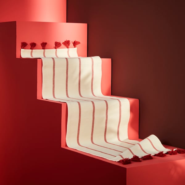 A red stairway with a white runner with red stripes.