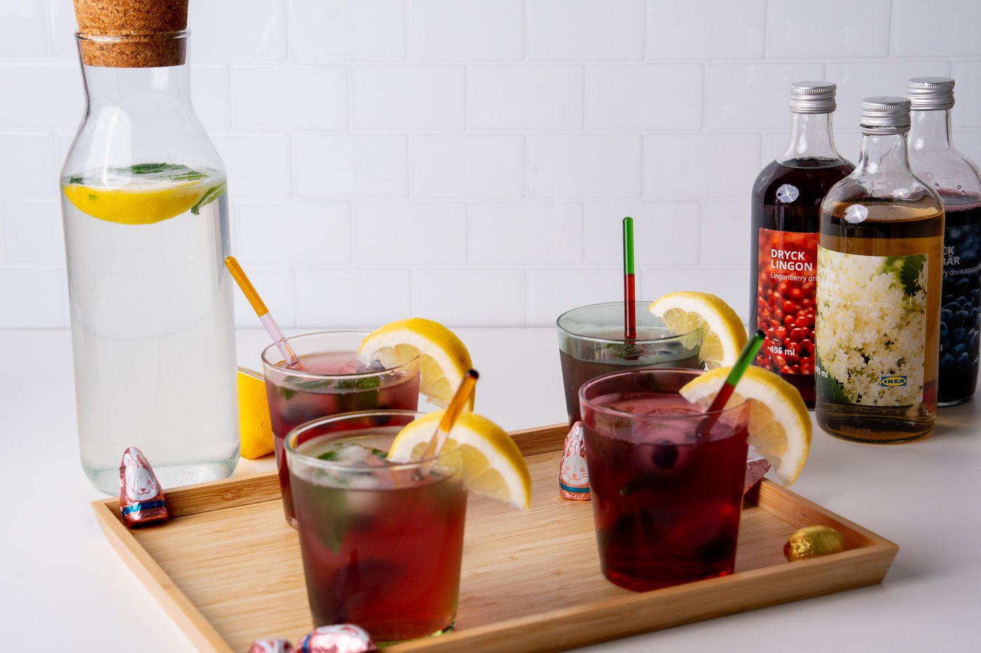 4 Gläser mit Limonaden auf einem Holztablett präsentiert