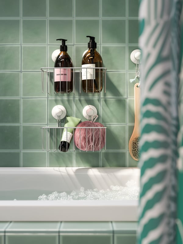 Duschgels und andere Duschutensilien finden sich hier in einem IMMELN Duschkorb mit Saugnäpfen über der Badewanne.