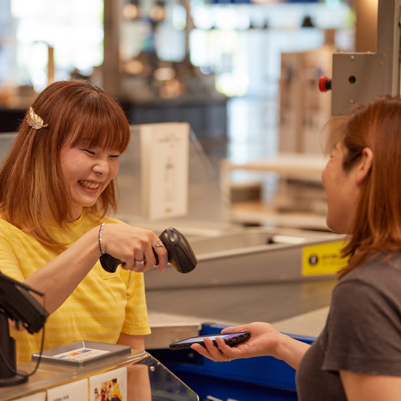 セルフレジでお客さまがスマートフォンをかざし、IKEA Scan & Payでキャッシュレス決済を利用している