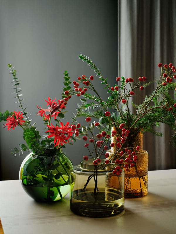 A plum blossom branch is placed in a clear TIDVATTEN vase by the windowsill in a pink-coloured bedroom.