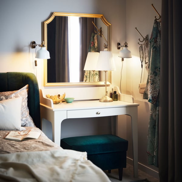 A light beige LOMMARP desk stands in a corner under a SVANSELE mirror beside a dark green TUFJORD upholstered bed.