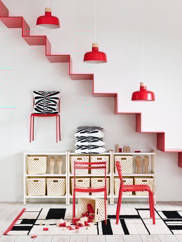 Pared con estanterías de color blanco y sillas rojas