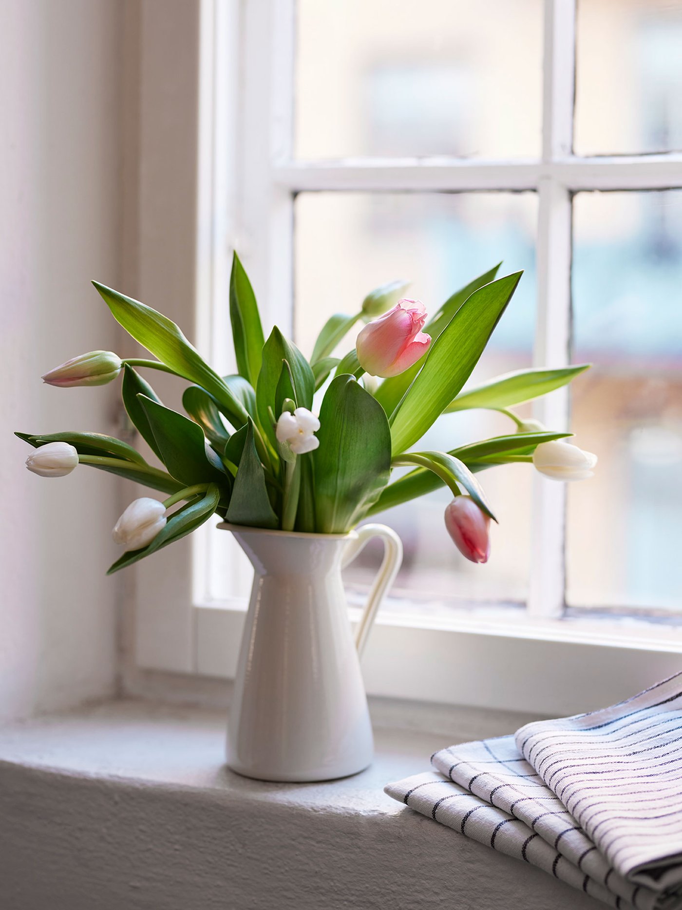 Ein Tulpenstrauß in einer SOCKERÄRT Vase.