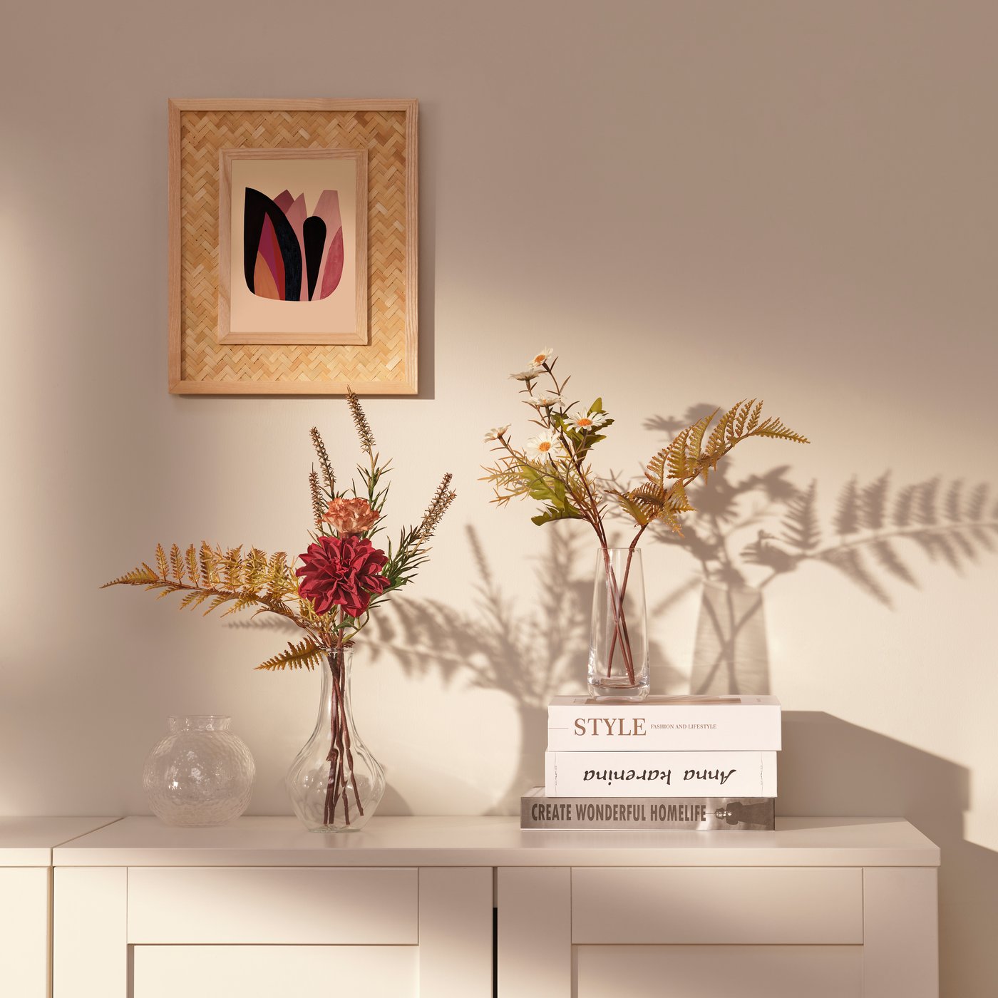 Eine VILJESTARK Vase aus klarem Glas mit künstlichen Pflanzen.