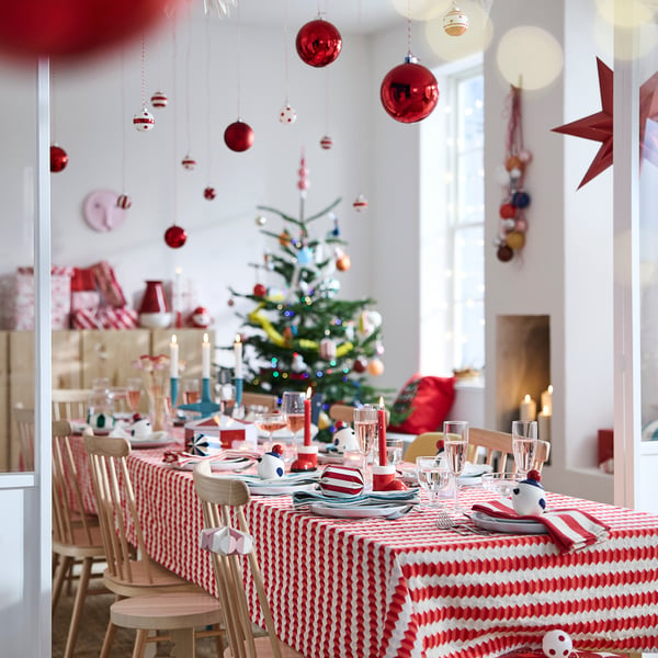 Juldukning med rutig duk och julgran i bakgrunden.