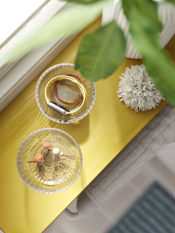 A wide, shallow drawer of a chest left ajar, revealing jewellery and beauty accessories, some of it in SAXBORGA trays.
