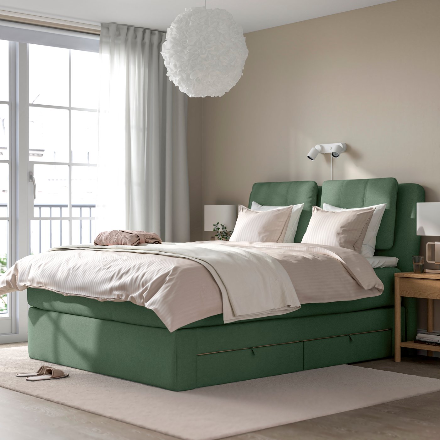 Ein festes VÅGSTRANDA/TUSSÖY-Tibbleby-grünes LILLFJÄLLET-Divanbett mit Stauraum im Schlafzimmer.
