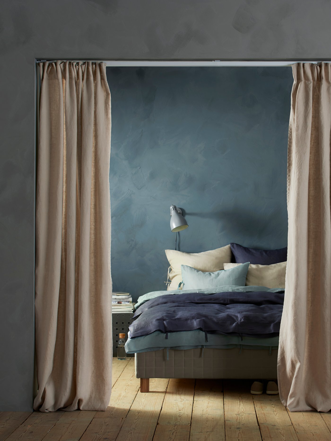 Chambre avec des rideaux qui permettent de diviser l'espace en deux.