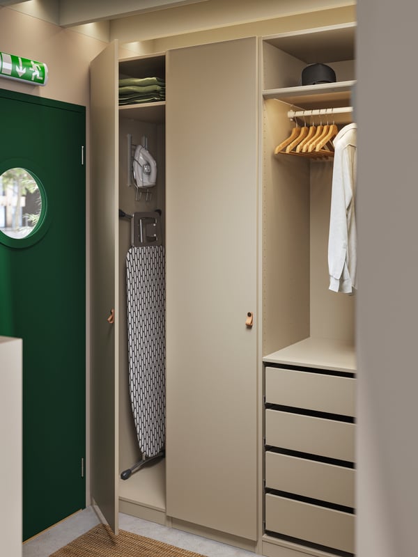 A hotel room with a PAX wardrobe with drawers, hangers, shelves and storage space for an iron and an ironing board.