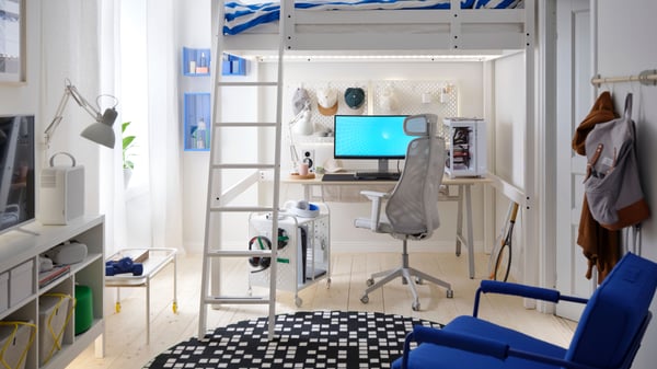 Under a loft bed is an airy, PC gaming setup with a light grey, mesh MATCHSPEL gaming chair and an UTESPELARE gaming desk.