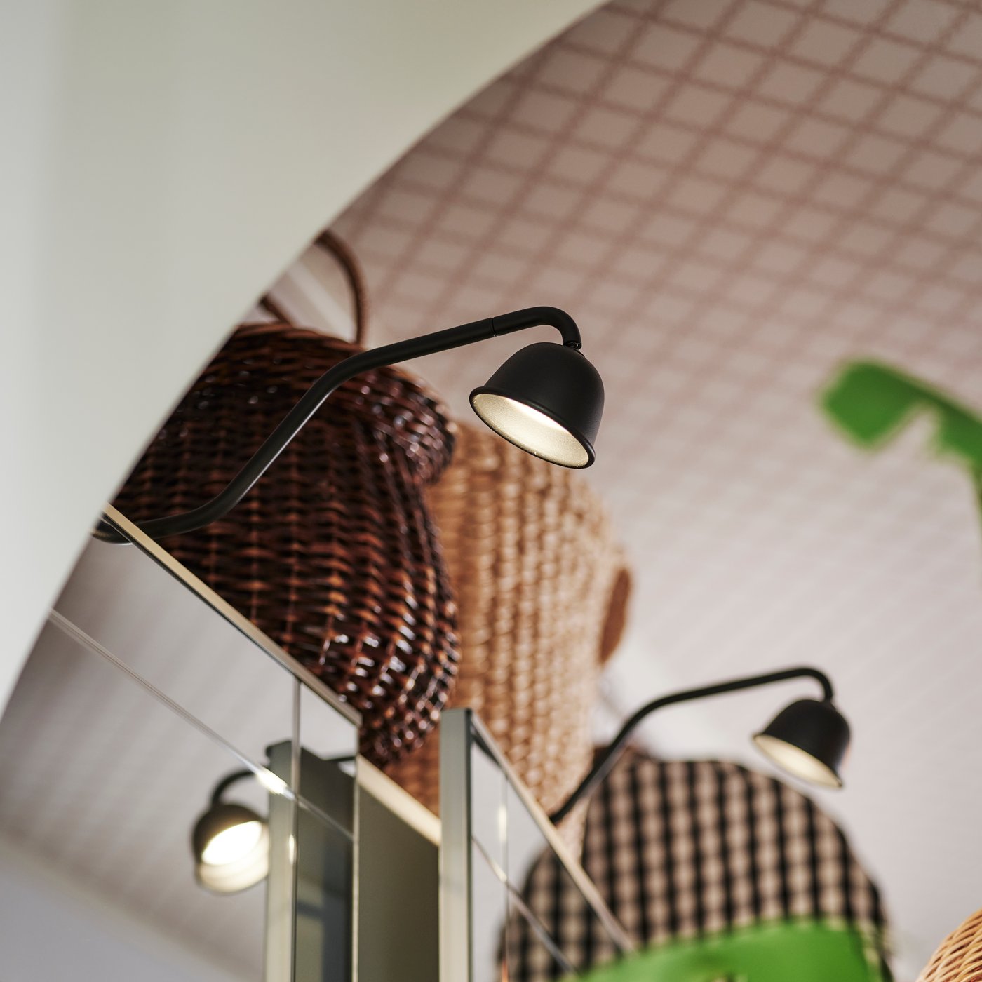 Toppen av en PAX/KAMMANTORP garderobskombination med en dörr som står lite på glänt och svart TVÄRDRAG skåpbelysning ovanpå.