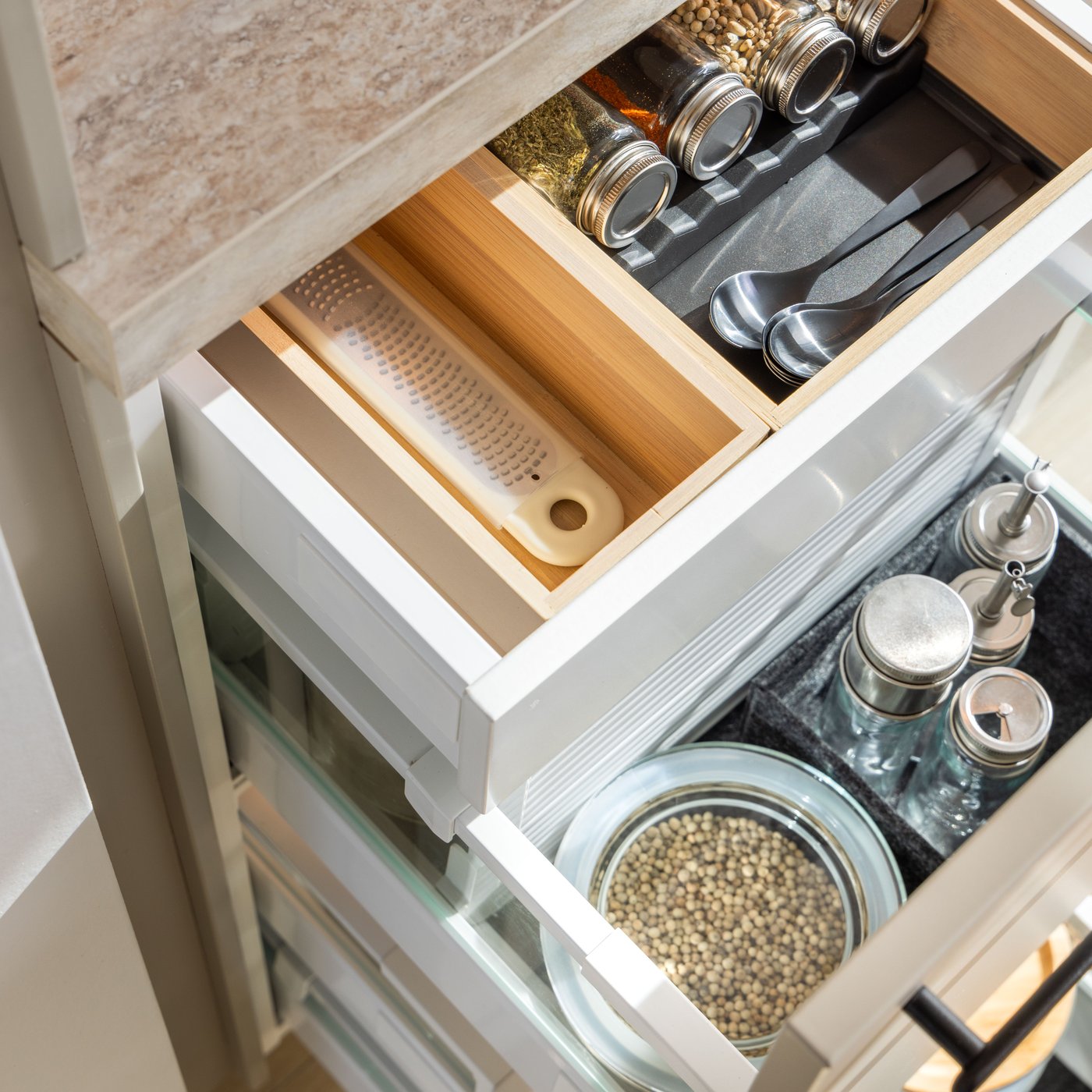 Cuatro cajones de cocina MAXIMERA extraíbles con varios elementos en un cubertero, organizador regulable para cajones y cajas.
