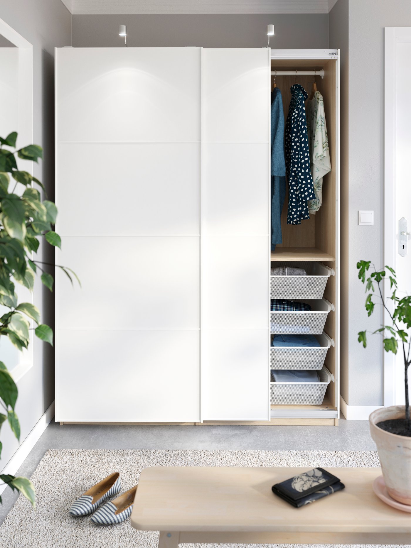 Weisser Kleiderschrank mit Schiebetüren und Spotlights in einer Zimmernische.