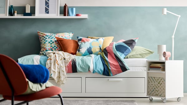 A section of a room with a white BRIMNES day-bed dressed with SVALSTJÄRTAR duvet cover and pillow cases.