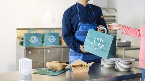 collaborateur IKEA tendant un sac too good to go à une cliente