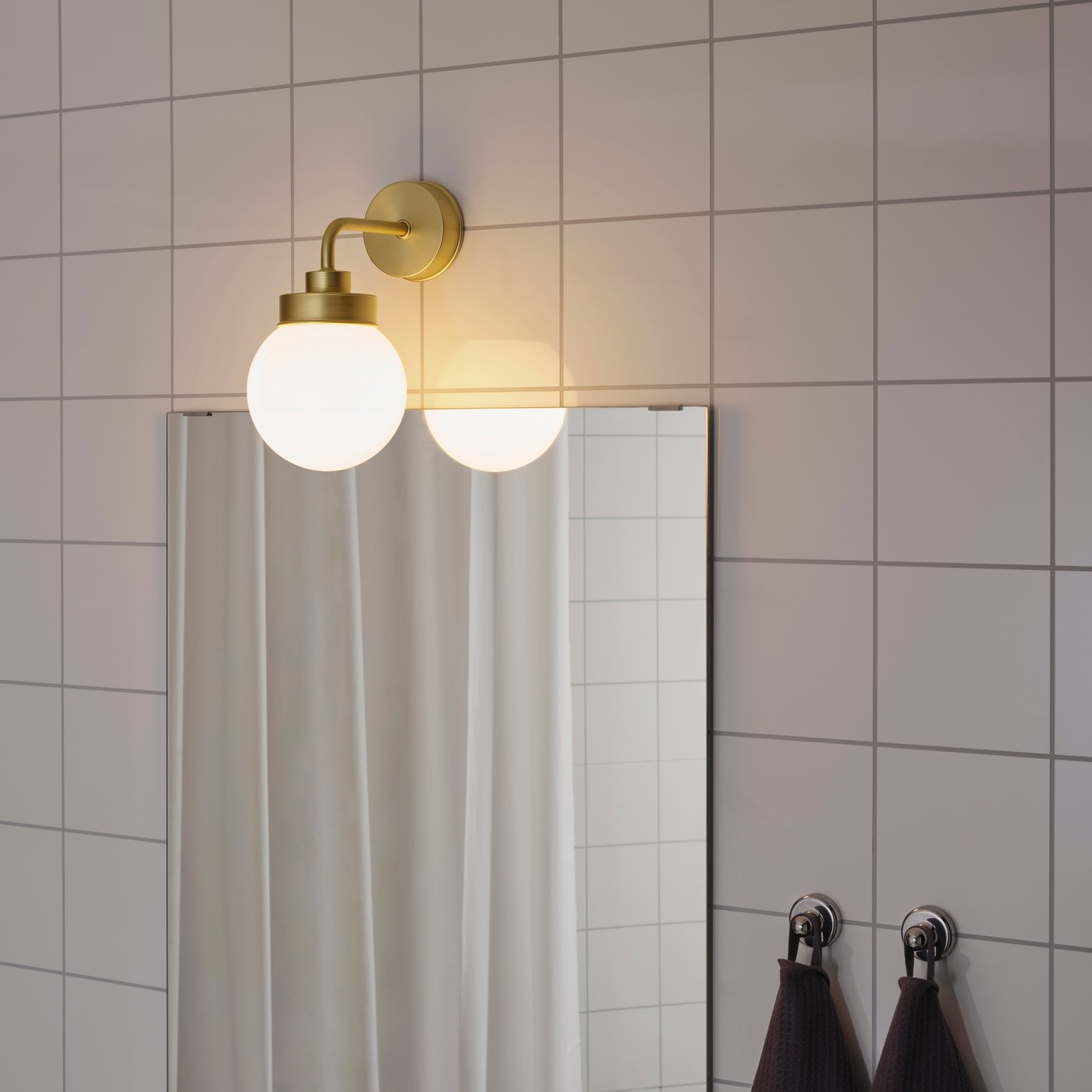 A brass-colour FRIHULT wall lamp