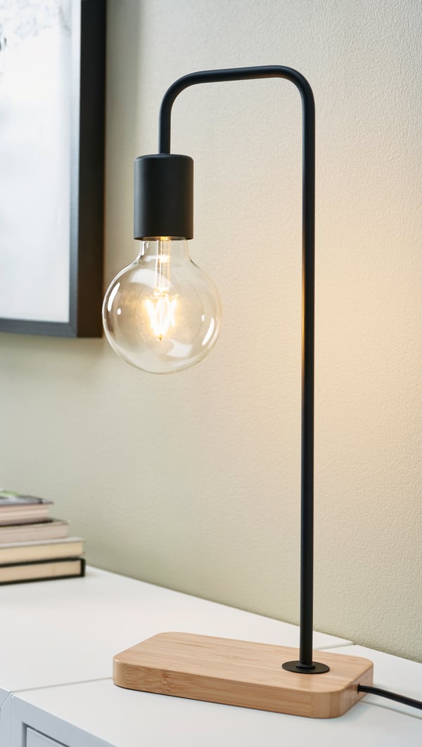 A black/bamboo TVÄRHAND table lamp