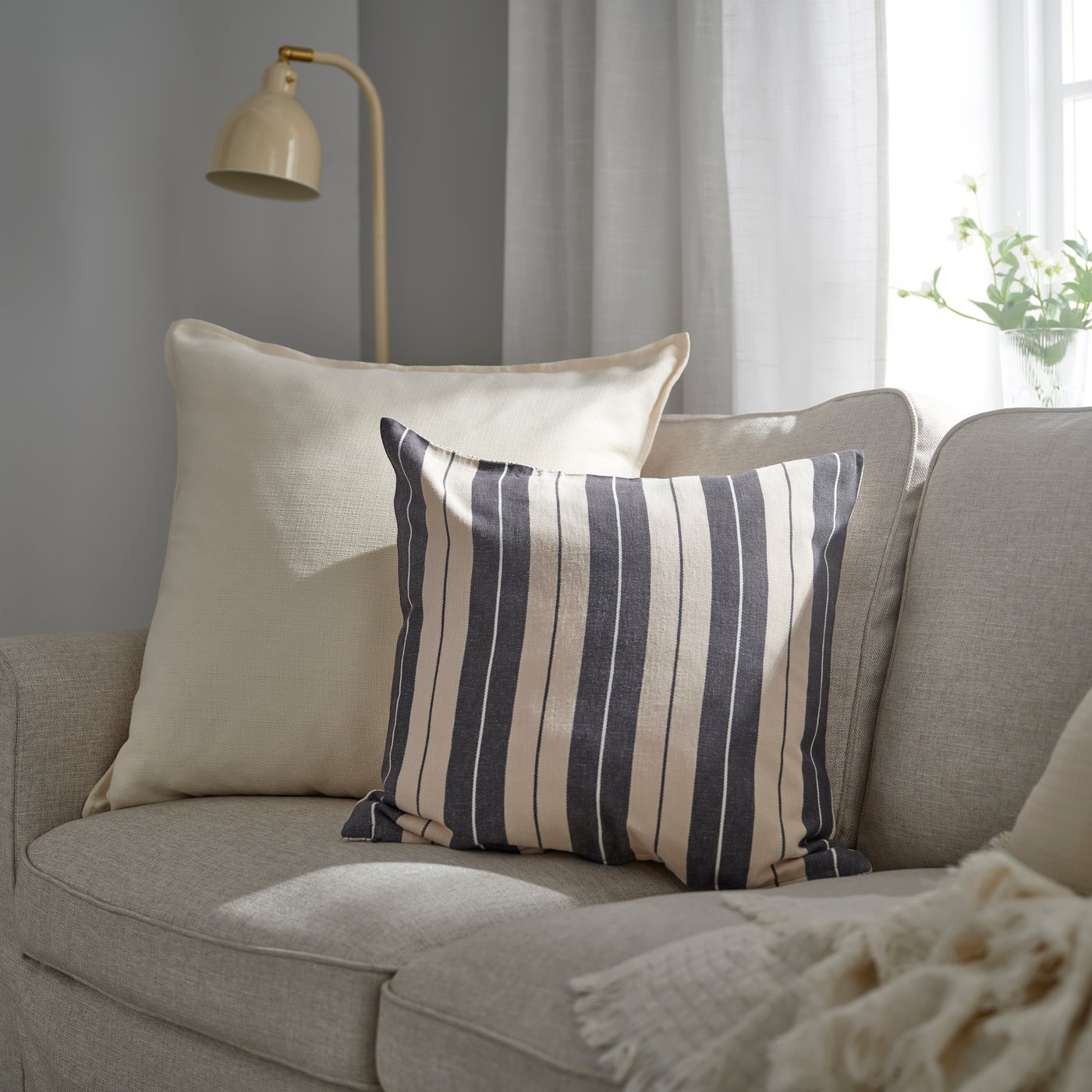 Blue and white striped pillow on a tan sofa
