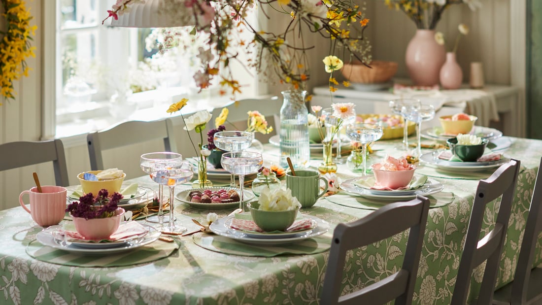 Una tavola apparecchiata con stile floreale sui toni del verde, con tazze verdi e rosa