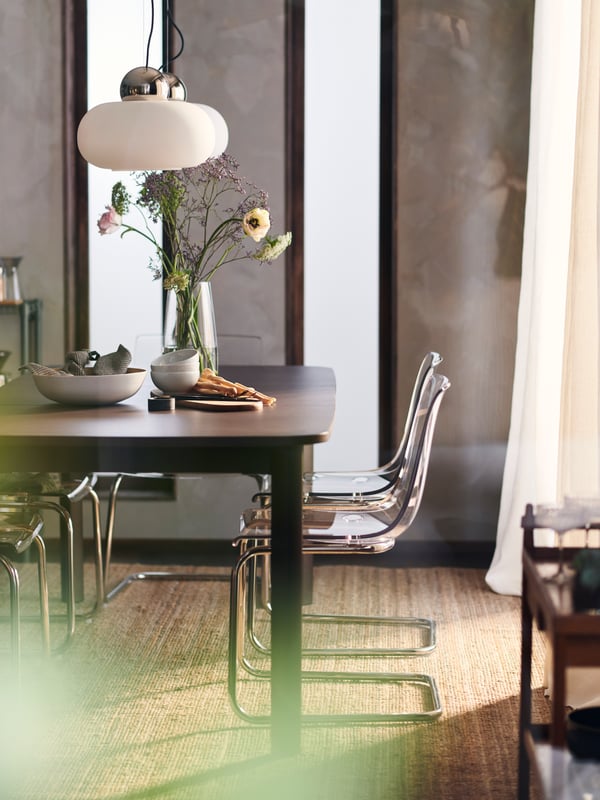 Des chaises modernes TOBIAS autour d’une table à manger foncée.