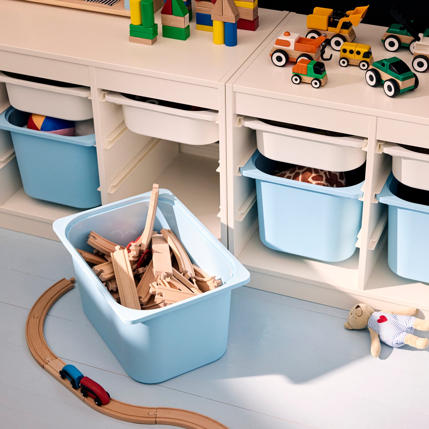 TROFAST storage system seen from above, with a light blue storage boxes pulled out to show LILLABO train rail pieces inside.