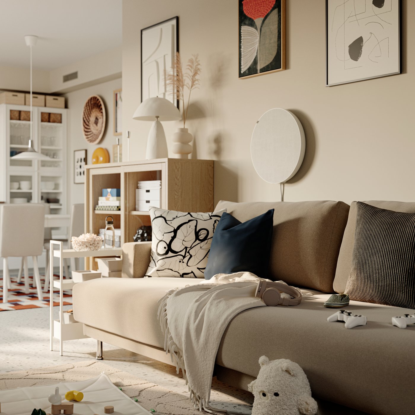 A GREJSIMOJS soft toy leans against an UPPÅKRA 3-seat modular sofa. A SOLSKYDD Bluetooth speaker is attached to the wall.