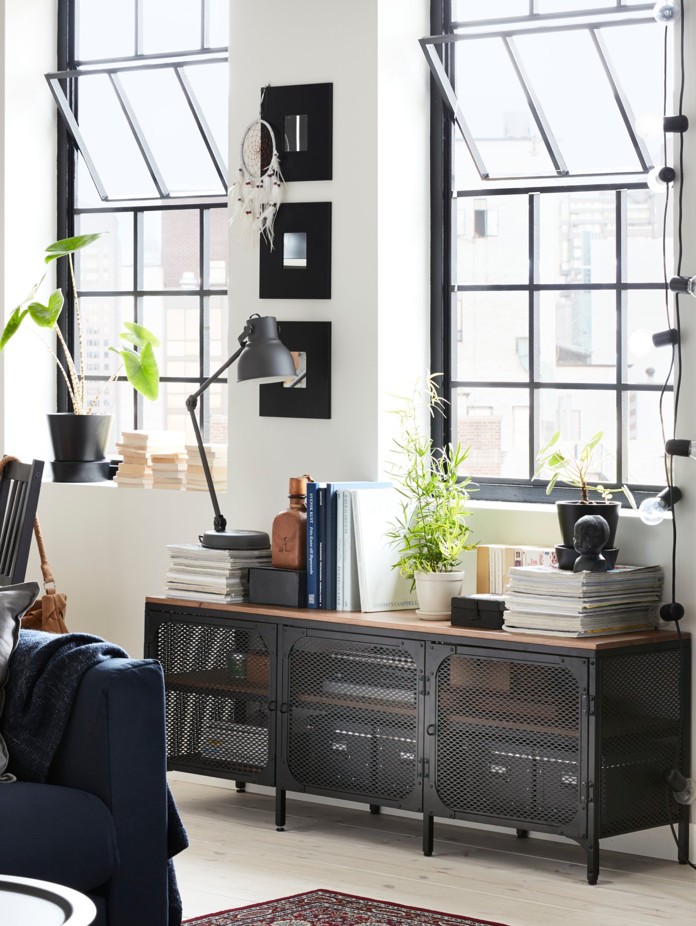 A dark grey HEKTAR work lamp with wireless charging in the living room
