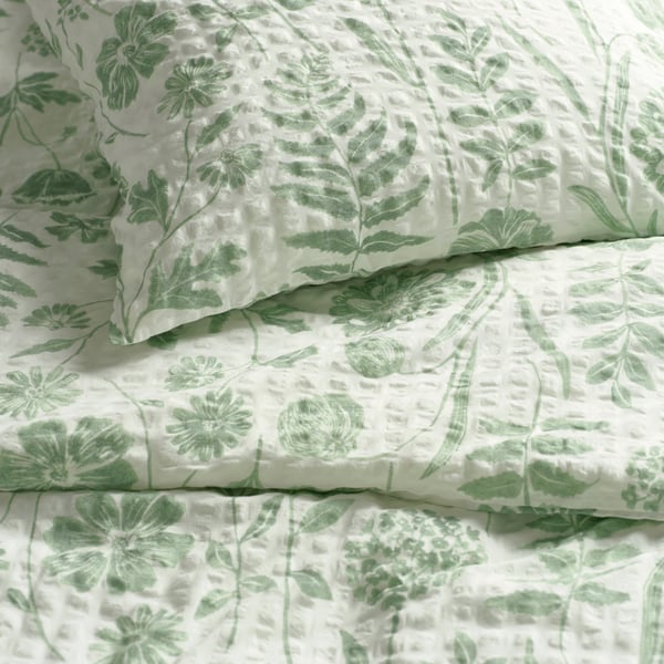 A white grey-green/floral pattern NÅLBJÖRNBÄR duvet cover and pillowcase