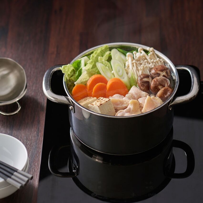 ポータブルIHクッキングヒーターの上で野菜やきのこを煮込んでいる鍋