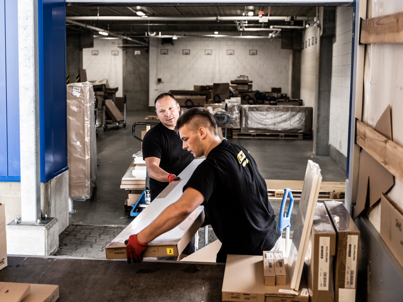 Deux collaborateurs qui déplacent un carton IKEA