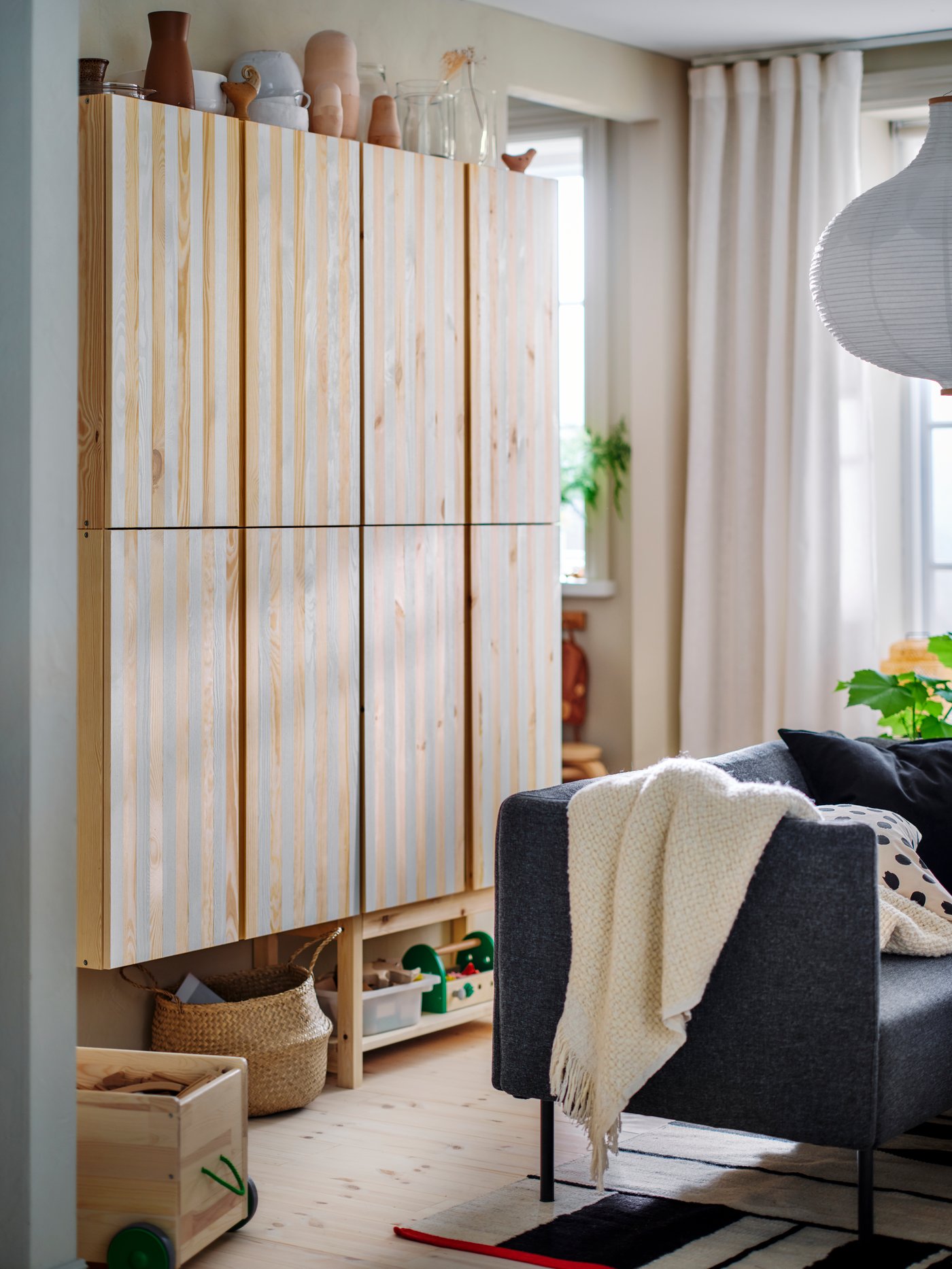 Modular LILLEHEM seating with a HUMLEMOTT throw and two extra cushions on top, in front of some IVAR storage.