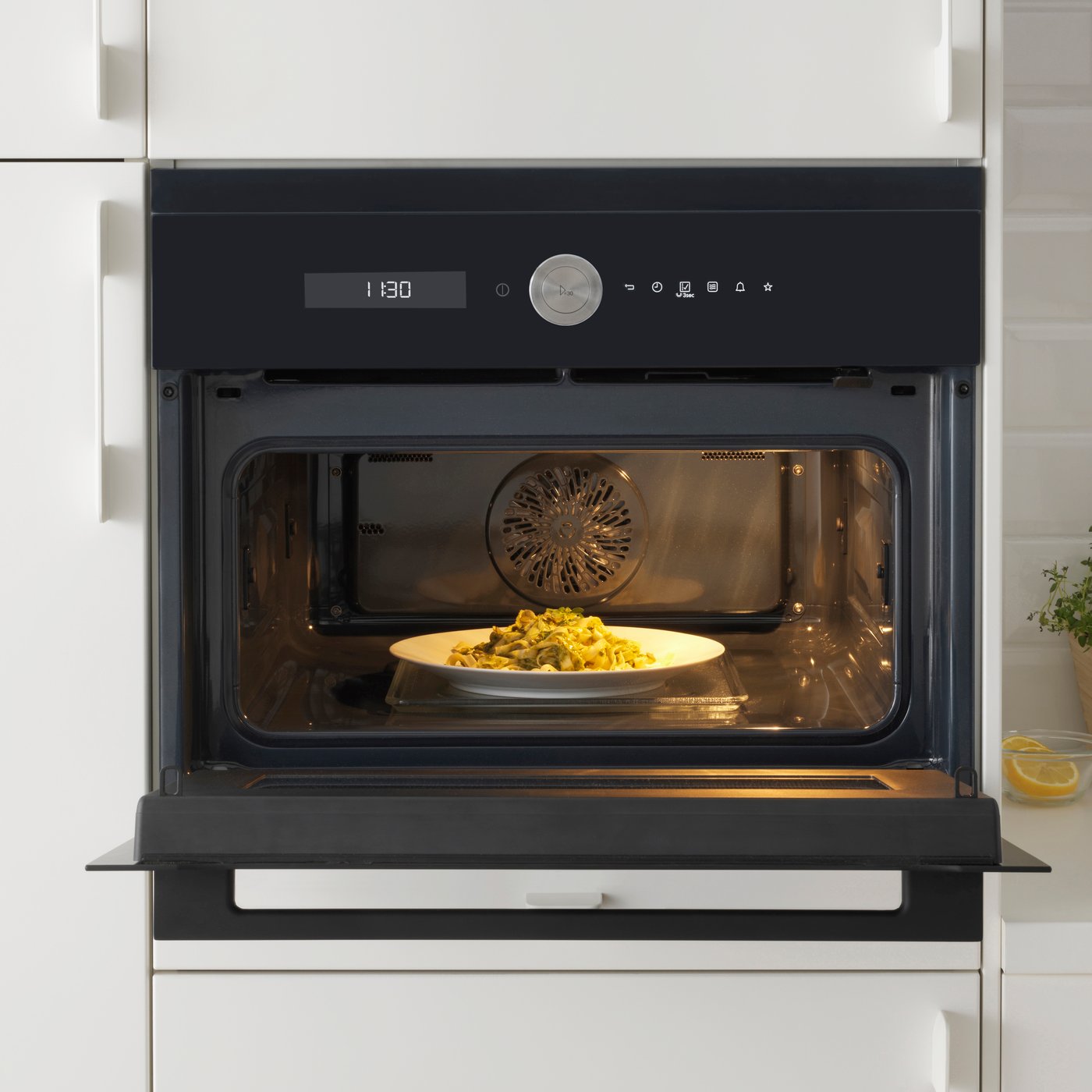 En åpen mikrobølgeovn med en middagsrett inni. 