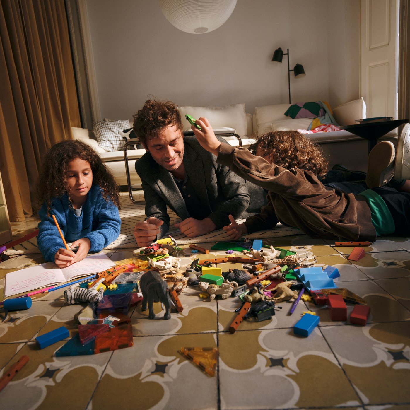 Father and children play in a room.