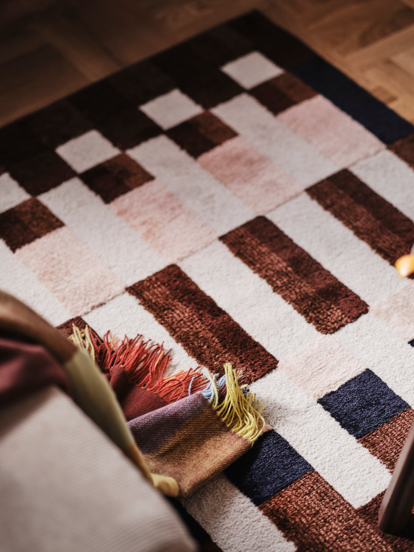En närbild av en geometriskt mönstrad matta i brunt, beige och svart.