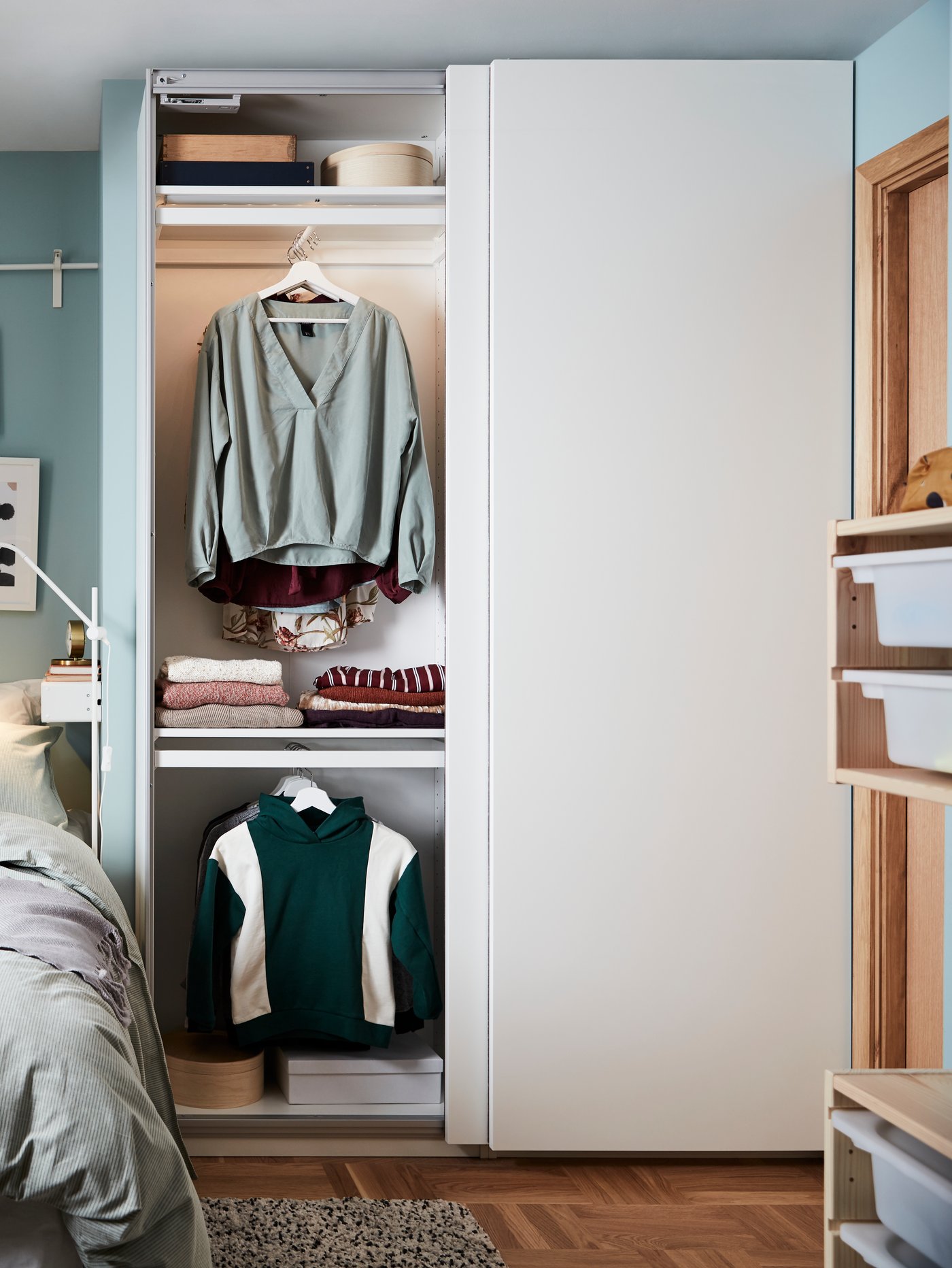 Bedroom with PAX wardrobe showing white HASVIK sliding doors. 